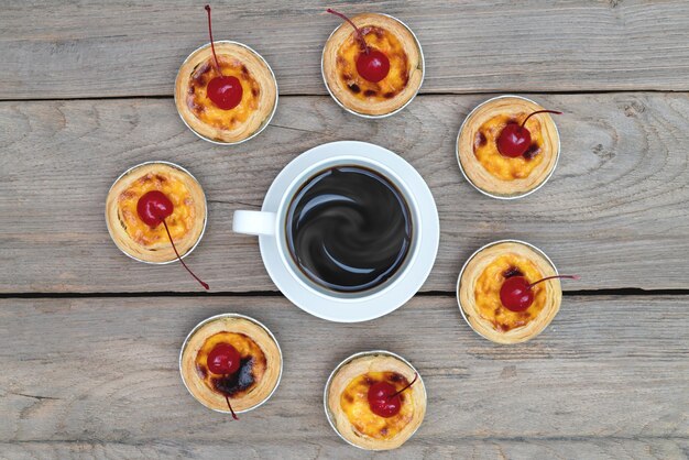 tasse de café avec tarte aux œufs sur une table en bois