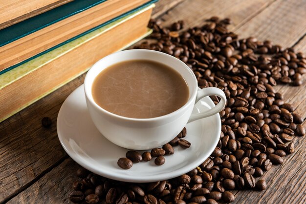 Tasse de café et tas de haricots sur une table en bois