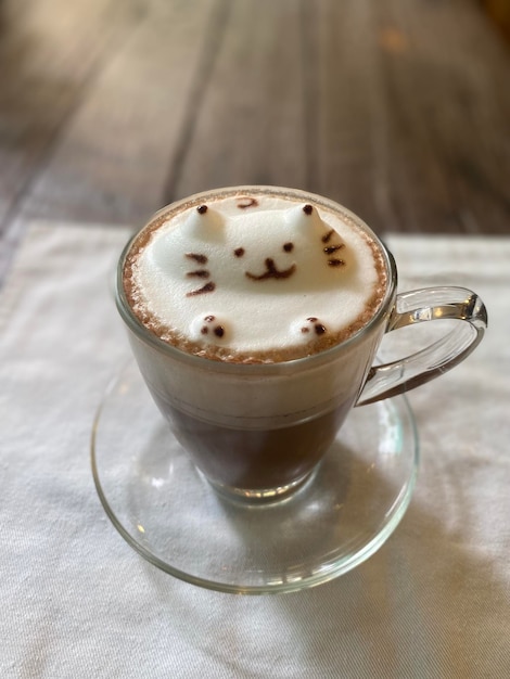 Une tasse de café avec une tête de chat dessus.