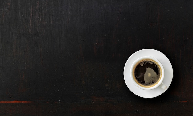 Tasse de café sur la texture du bois peint noir