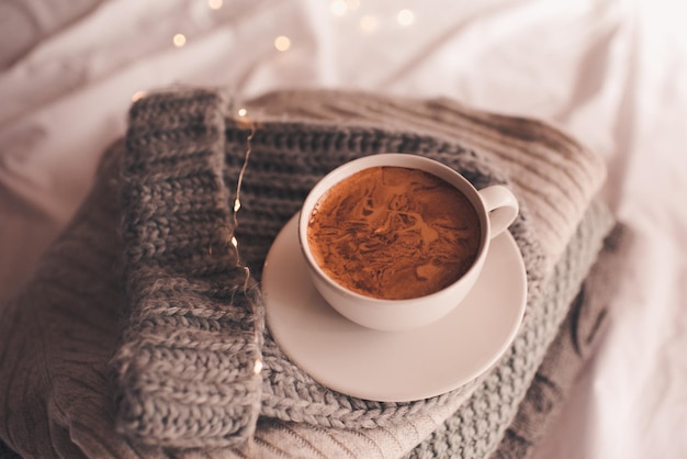 Tasse de café sur des tissus tricotés au lit se bouchent. Saison des vacances d'hiver. Bonjour.