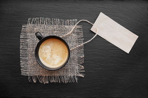 Tasse à café sur toile de jute rustique et carte papier vierge