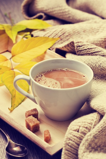 Tasse de café et des vêtements chauds sur fond de bois ancien