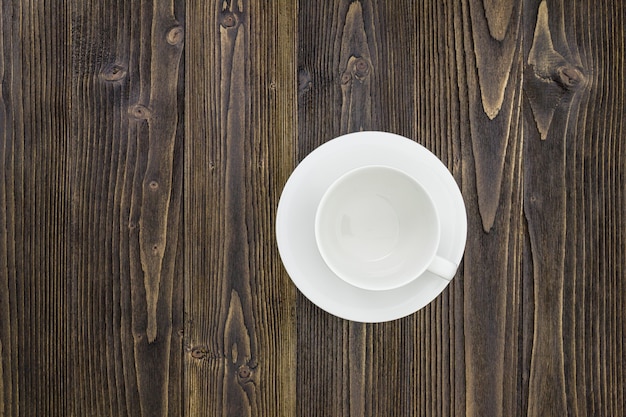 Tasse à café vide sur fond de table en bois.