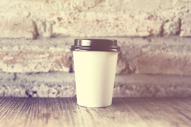 Tasse de café vierge sur un fond de mur de briques