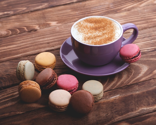 Tasse De Café Violet Et Macarons Sur La Table En Bois