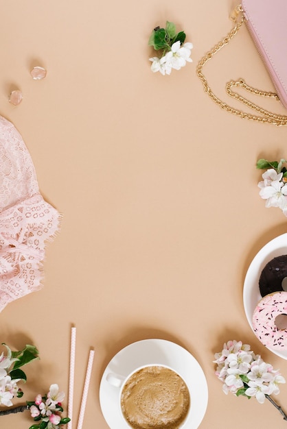 Tasse à cappuccino beignets fleurs sac à main chemisier rose sur fond beige avec copie espace plat élégant tendance fashion blogger