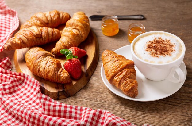Tasse de cappuccino café confiture fraises et croissants