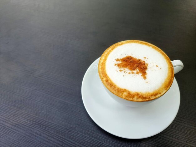 Une tasse de cappuccino chaud est sur la table