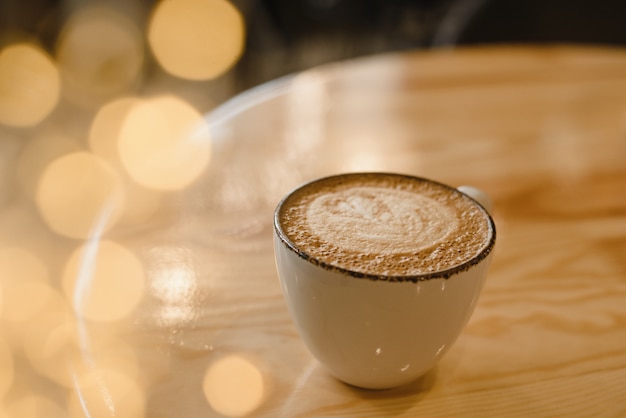 Tasse de cappuccino chaud sur une table en bois