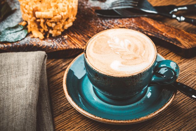 Tasse à cappuccino avec latte sur fond de bois Belle tasse en céramique verte mousse