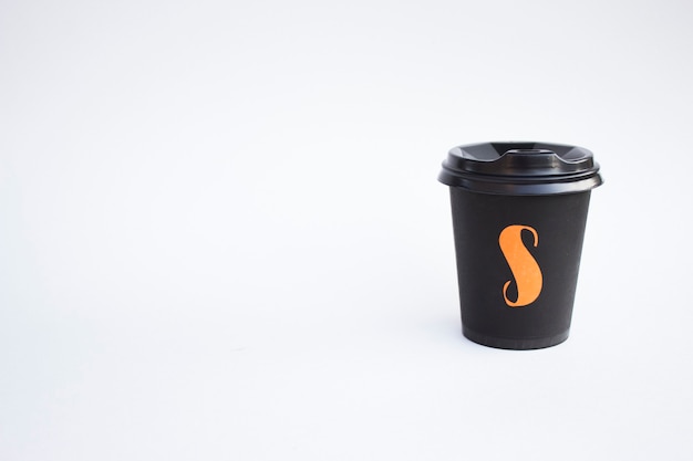 Tasse en carton noir jetable isolée sur une surface blanche, tasse Eco pour café et thé. Concept d'idée d'écologie.