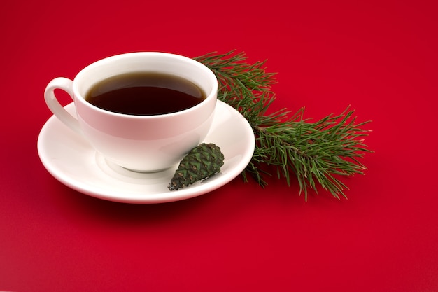 Tasse en céramique avec café chaud et branche de pin