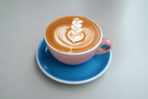 Une tasse de céramique de café latte chaud sur une table blanche