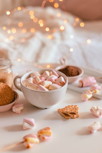 Tasse en céramique de chocolat chaud ou de cacao avec guimauve sur tableau blanc