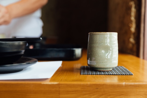 Tasse en céramique japonaise de thé vert sur une table en bois.