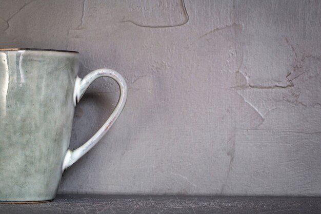 Photo tasse en céramique avec motif en pierre naturelle gris mousse blanche avec fond de mur en béton