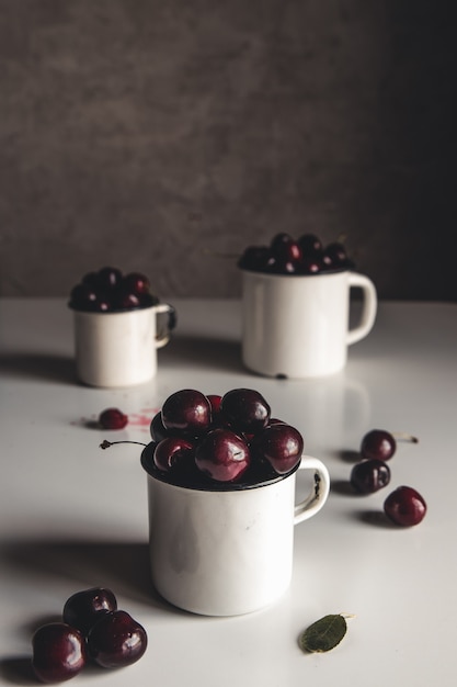 Une tasse de cerises douces sur fond de béton. Produit écologique biologique, ferme. Pas d'OGM