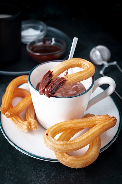 Tasse avec chocolat chaud et assiette avec churros