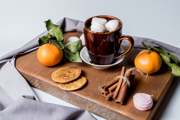 Tasse de chocolat chaud aux guimauves, cannelle, mandarine, fruits confits à l&#39;orange.