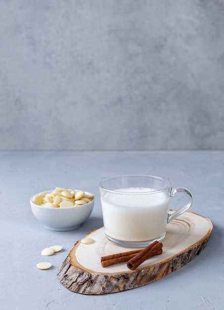 Une tasse de chocolat chaud blanc sur un support en bois sur une surface grise. Boissons céto. Copiez l'espace.