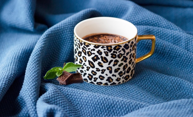 Une tasse de chocolat chaud sur la couverture douillette bleue