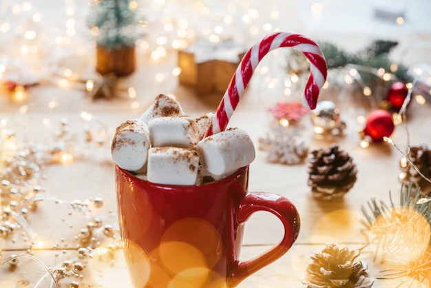 Tasse de chocolat chaud de guimauve de Noël avec la canne de sucrerie