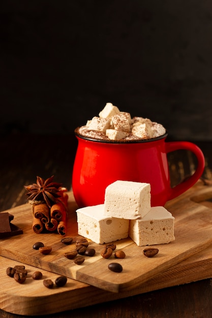 Une tasse de chocolat chaud, avec des guimauves, sur un fond sombre, vertical, rustique, pas de gens,