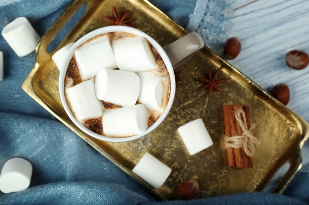 Tasse de chocolat chaud avec des guimauves sur le plateau