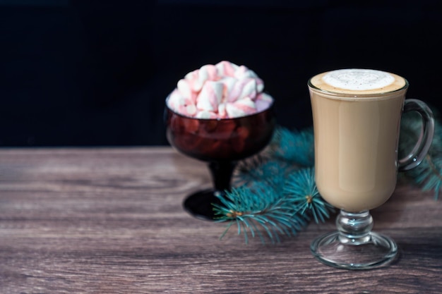 Une tasse de chocolat chaud avec des guimauves sur une table en bois