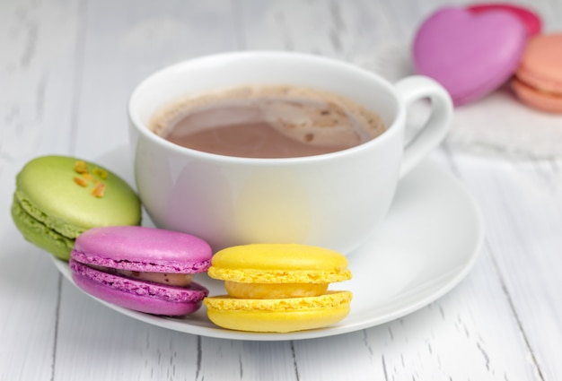 Une tasse de chocolat chaud avec des macarons colorés