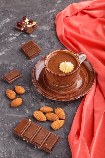 Tasse de chocolat chaud et morceaux de chocolat au lait aux amandes