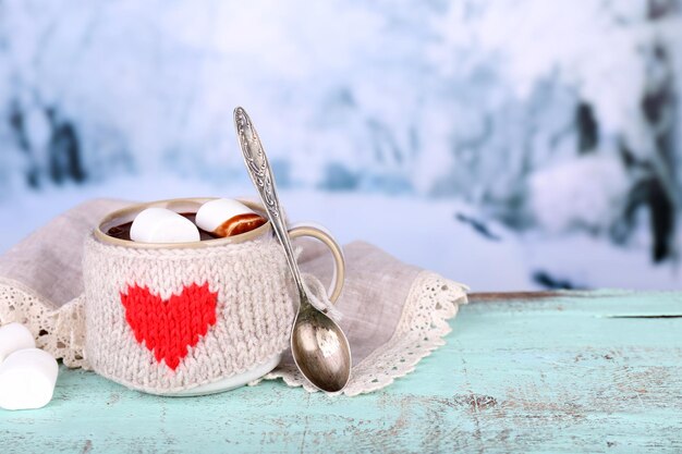 Tasse de chocolat chaud savoureux, sur table en bois, sur fond clair