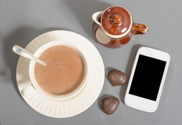 Tasse de chocolat chaud avec un téléphone