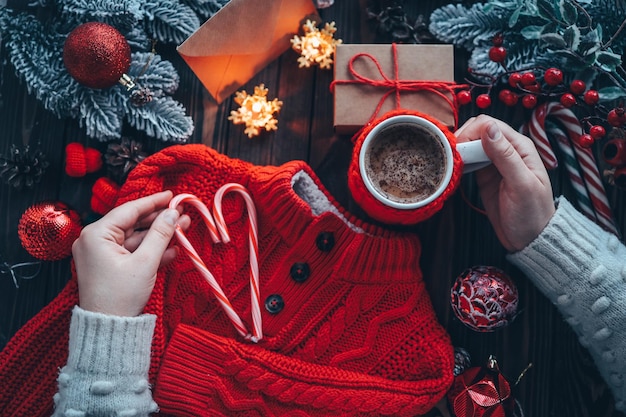 Une tasse de délicieux cacao dans les mains sur fond d'ambiance de Noël confort à la maison