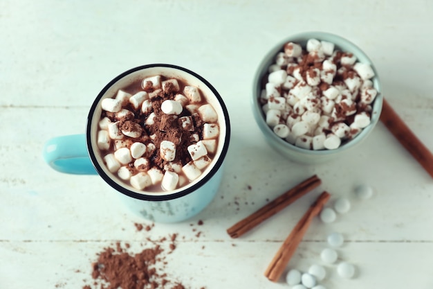 Tasse de délicieux cacao et guimauves sur tableau blanc