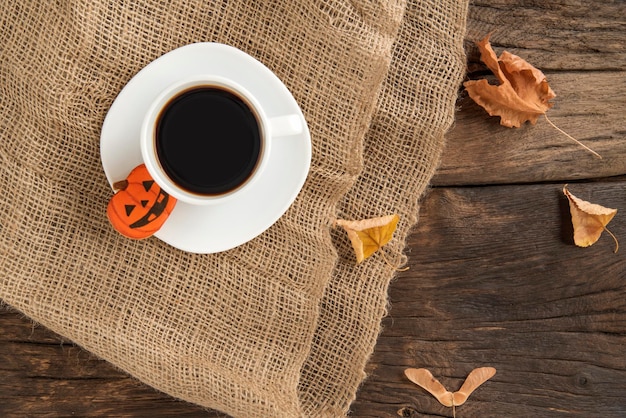 Tasse de délicieux café et pain d'épice d'Halloween en forme de citrouille sur une table en bois marron Vue de dessus d'automne