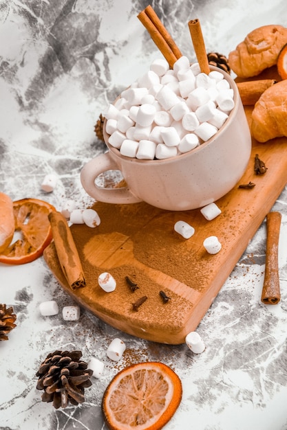 Une tasse de délicieux chocolat chaud de noël nouvel an et cacao avec des guimauves saupoudrées de cacao...