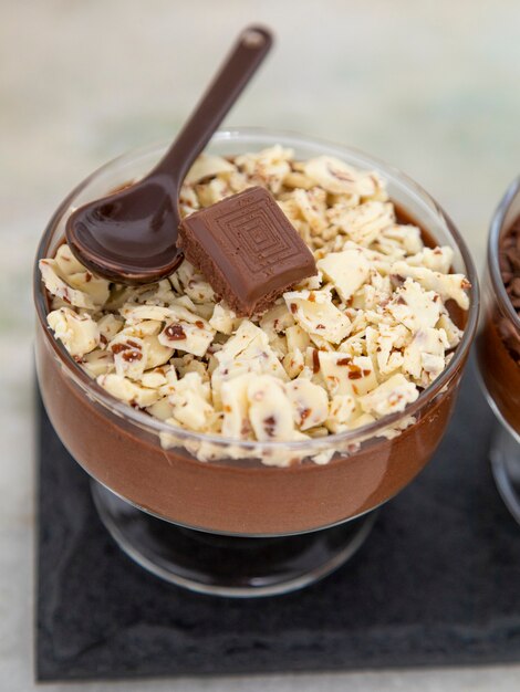 Tasse de dessert avec mousse au chocolat au lait et copeaux de chocolat blanc