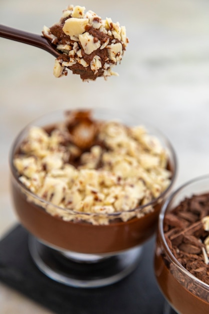 Tasse de dessert avec mousse au chocolat au lait et copeaux de chocolat blanc