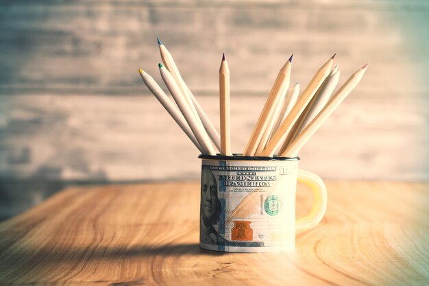 Tasse dollar avec des crayons