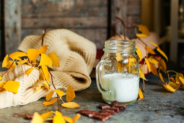 tasse avec du lait et des biscuits sur la table, les feuilles d'automne