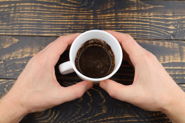 Tasse avec du marc de café dans les mains