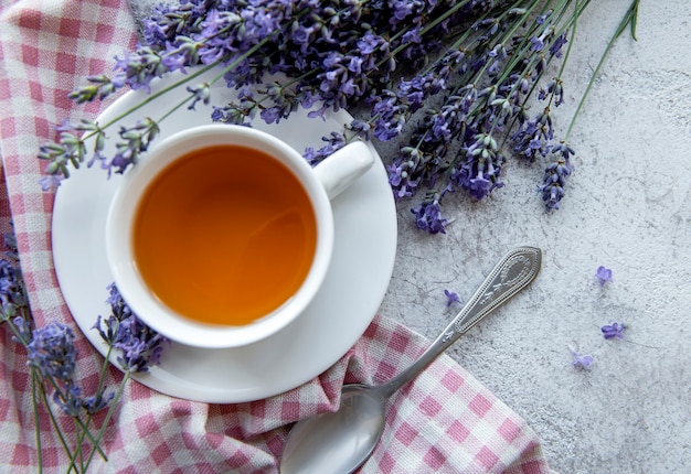 Tasse avec du thé à la lavande et des fleurs de lavande fraîches