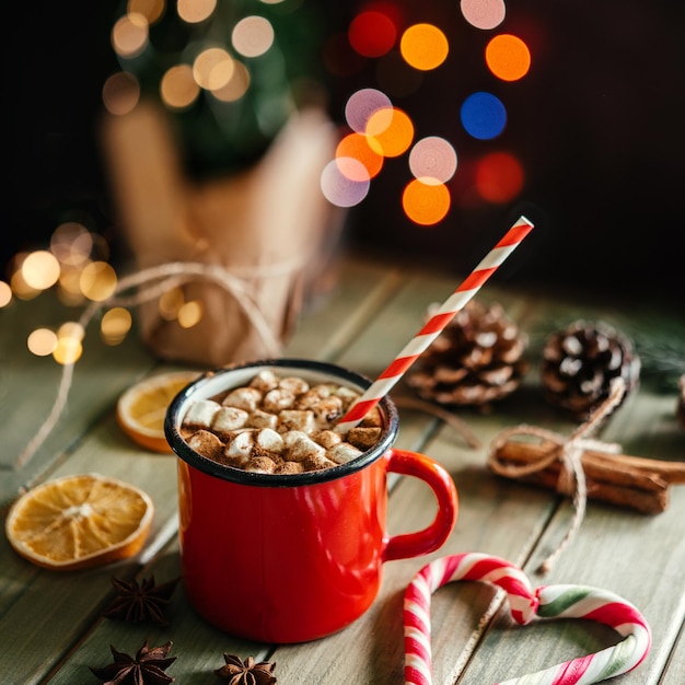 Tasse en émail rouge de chocolat chaud avec guimauve sur fond de Noël