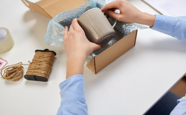 tasse d'emballage des mains à la boîte aux colis au bureau de poste