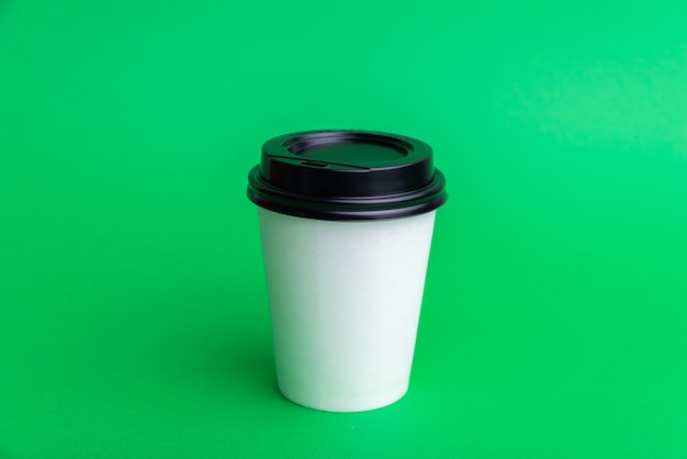 Une Tasse à Emporter Blanche Avec Capuchon Noir Sur Fond Vert