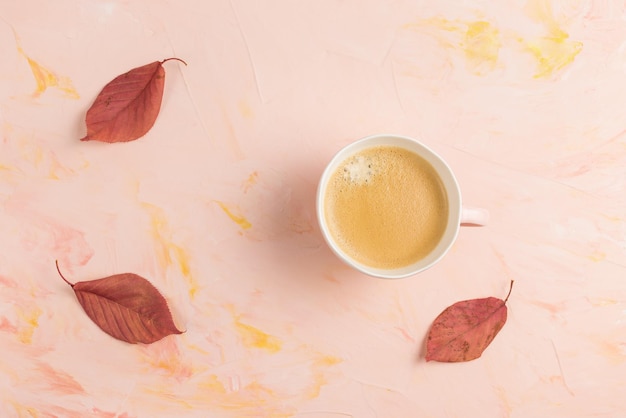 Tasse d'espresso et de feuilles d'automne jaunes sur l'espace de copie rose Ambiance d'automne