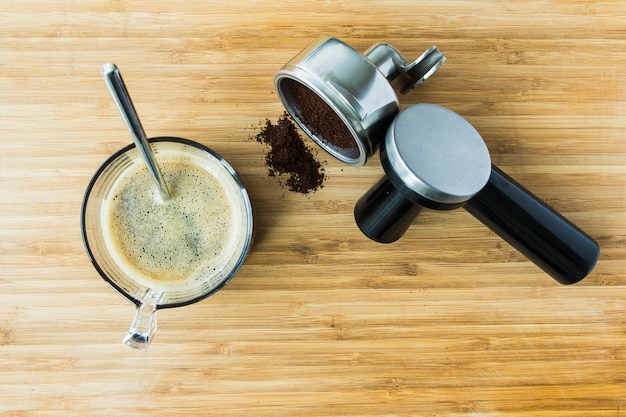 Tasse d&#39;espresso sur planche de bois avec du café moulu