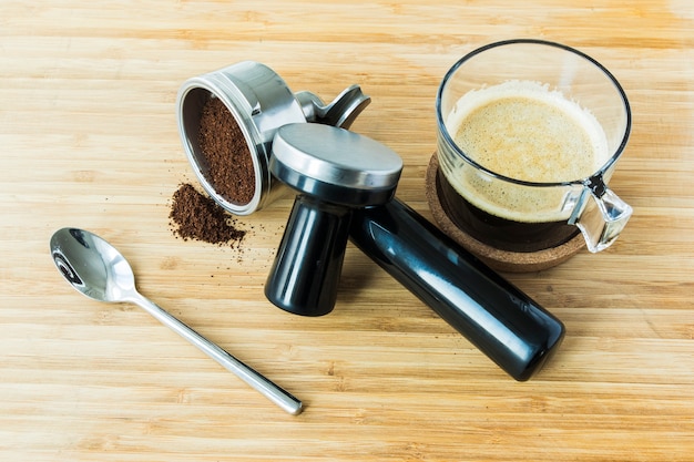 Tasse d&#39;espresso sur planche de bois avec du café moulu